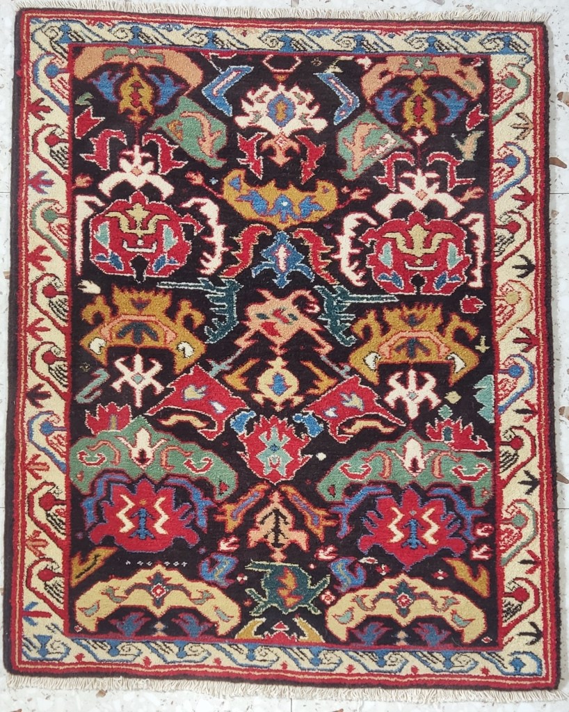 Caucasian tribal rug in the Zeikhur “Bijov” pattern, with dark field and stylized motifs in red, ivory, green, and blue.