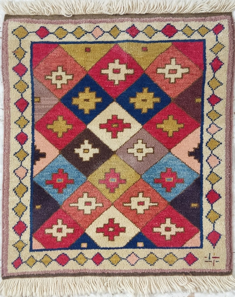 Caucasian Moghan-style bagface with multicolored diamond lattice design and cruciform motifs, framed by a geometric border on an ivory ground.